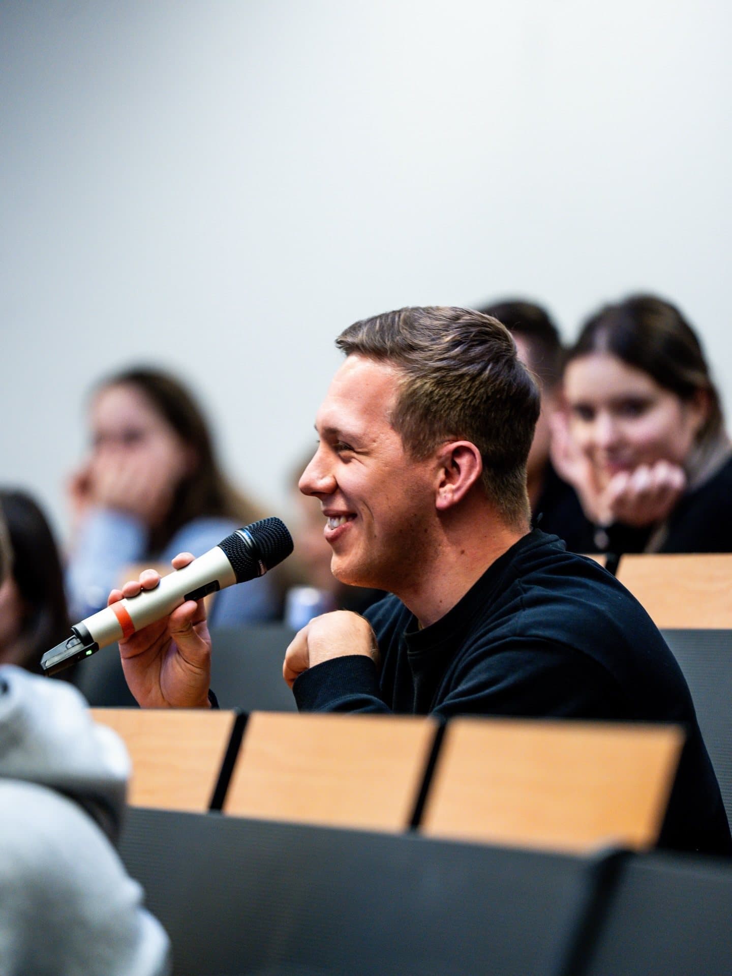 Student v publiku DIALOQ pokládá otázku do mikrofonu